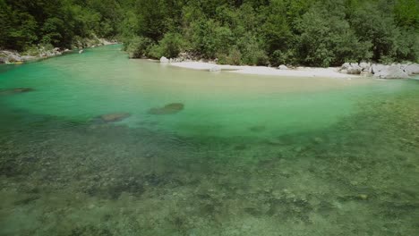 aerial view of the calm and transparent water at the soca river in slovenia.