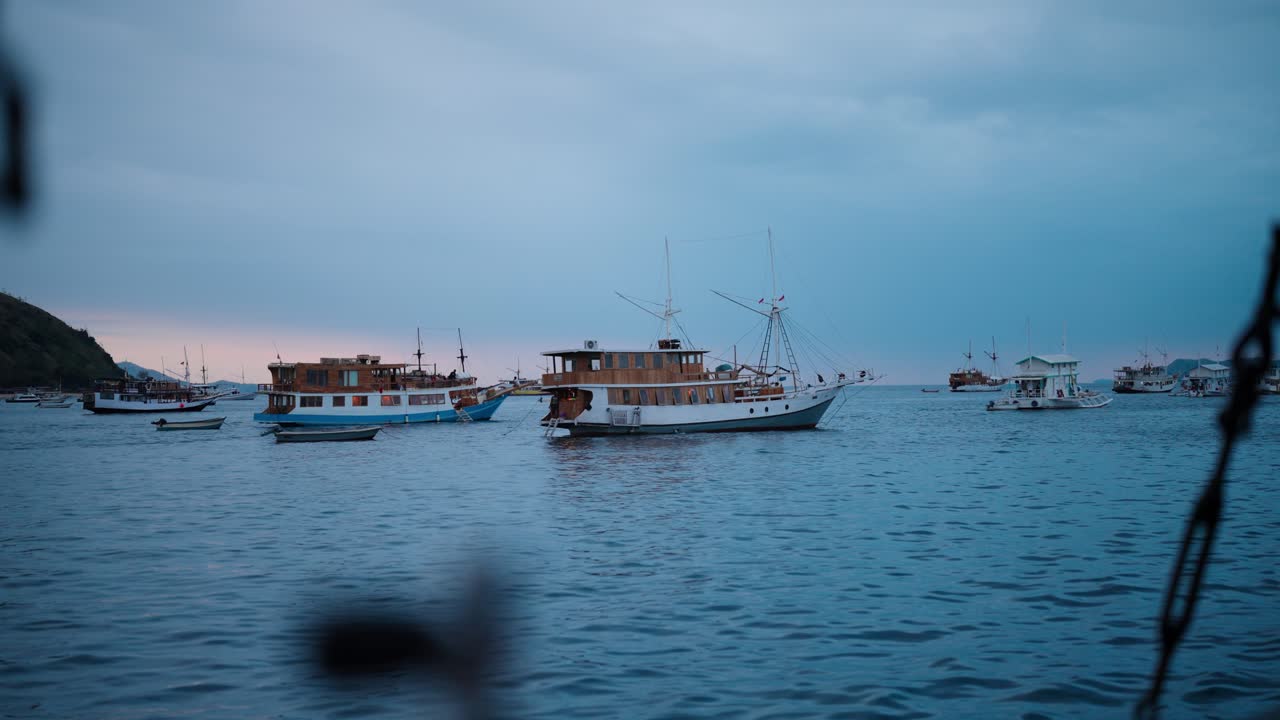 Un gruppo di classiche barche in legno adibite ad abitazione ancorate in acque oceaniche calme nelle Isole Komodo in Indonesia