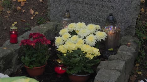 a grave adorned with candles and flowers, symbolizing remembrance and reverence in a solemn setting