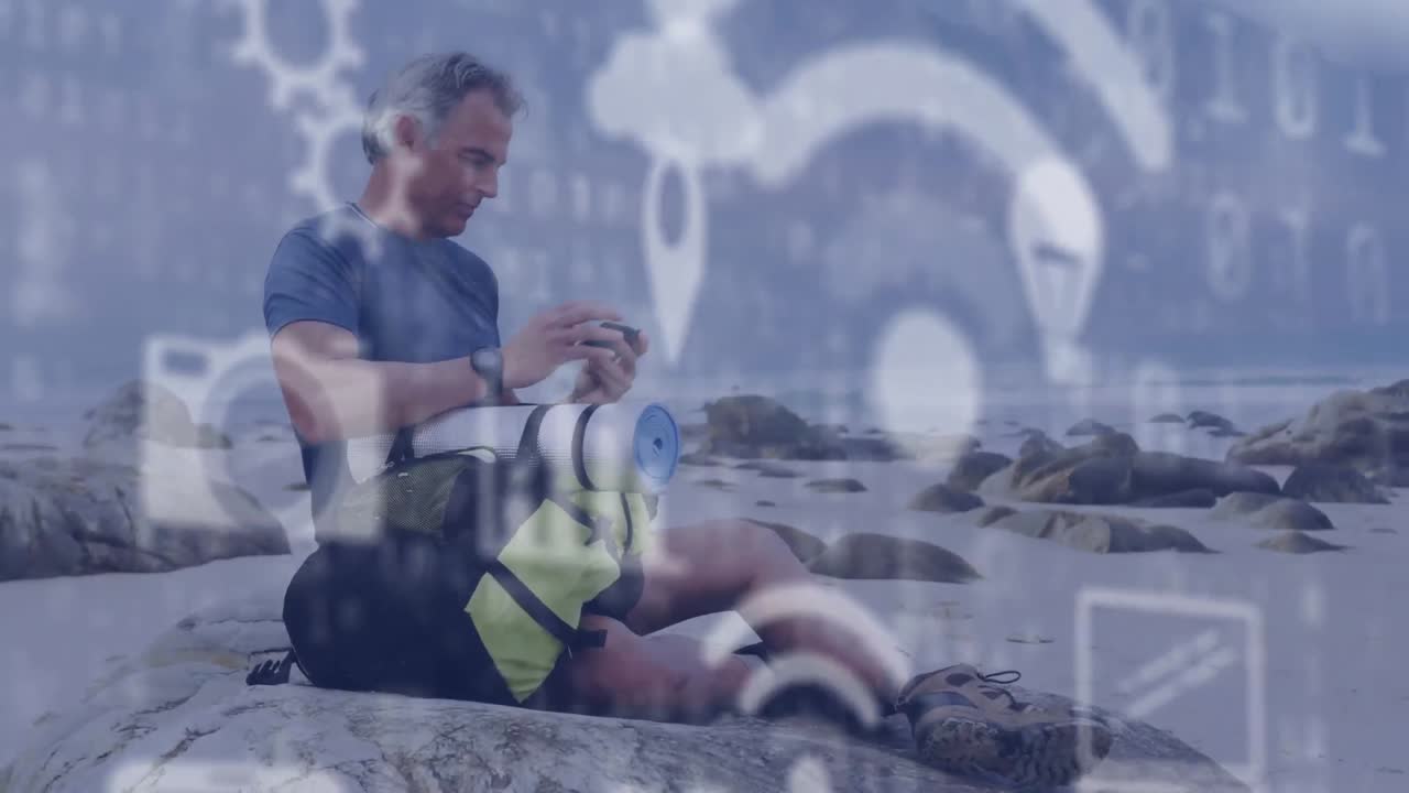 Animazione di icone digitali online e codice binario sopra un uomo anziano in riva al mare che usa lo smartphone.