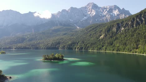 aerial drone shot of alpine lake that looks like carribbean with mountains in the background