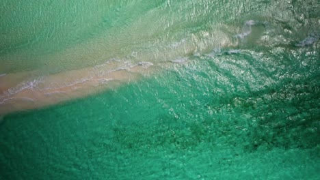 olas turquesas arrastrándose en una playa de arena en los rocas, venezuela, vista aérea