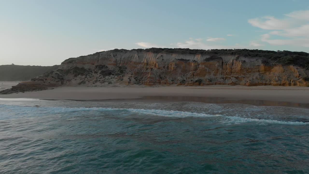 Aerial shot moving forward to the cliffs at red bluff surfing beach at Lake Tyers