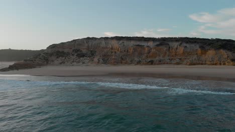 toma aérea avanzando hacia los acantilados en la playa de surf de red bluff en el lago tyers