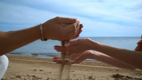 Amor-Pareja-Divirtiéndose-En-La-Playa-De-Arena.-Arena-Saliendo-De-Las-Manos