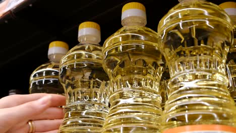 woman chooses vegetable oil while shopping in a grocery supermarket. high quality 4k footage