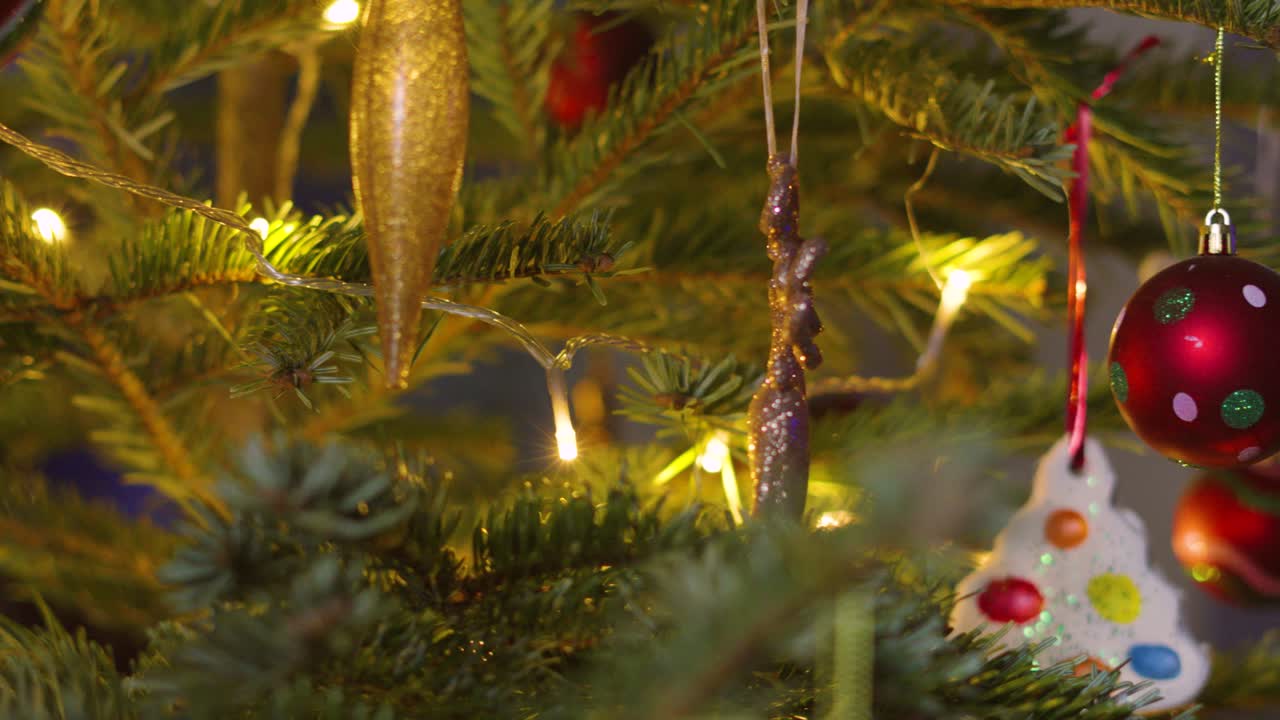 Overview of Christmas Fir Tree with Various Ornaments including Bourballs and Xmas Lights Wrapped on Branches. Holidays Festive Seasonal Footage 4K Video Background.
