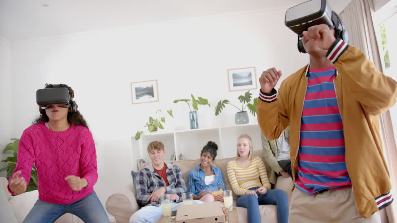 un grupo feliz de amigos adolescentes con pizza jugando con auriculares vr en casa, en cámara lenta