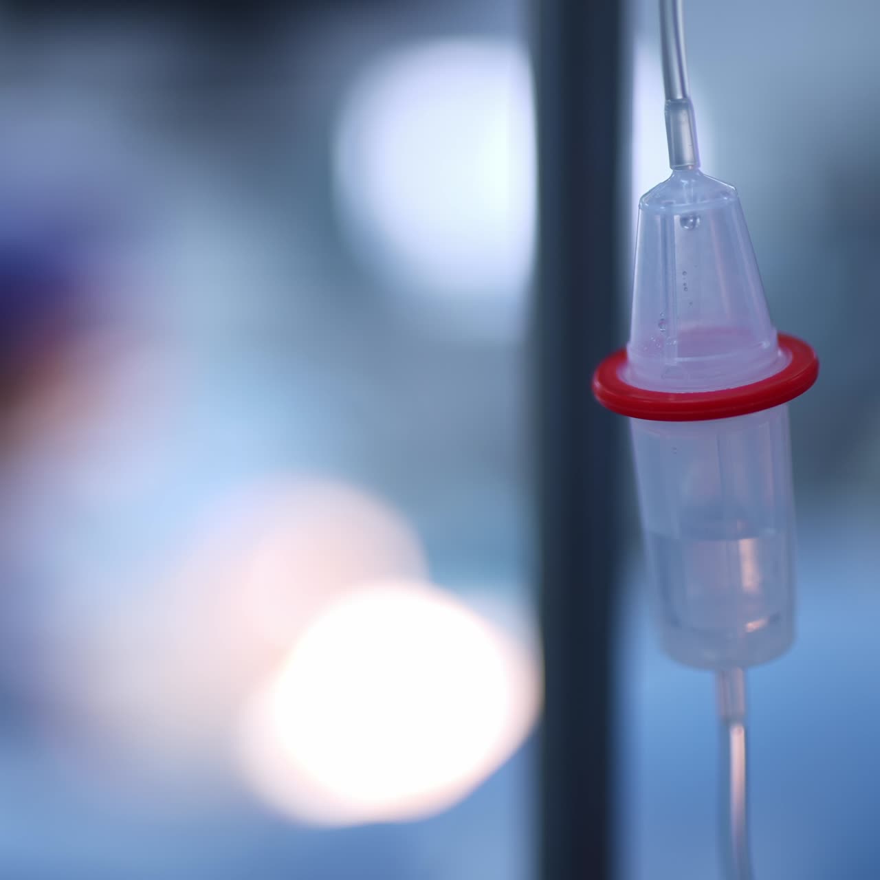 Slowly dripping drops of medicines in the drop counter. Equipment necessary at operation. Close up. Blurred backdrop