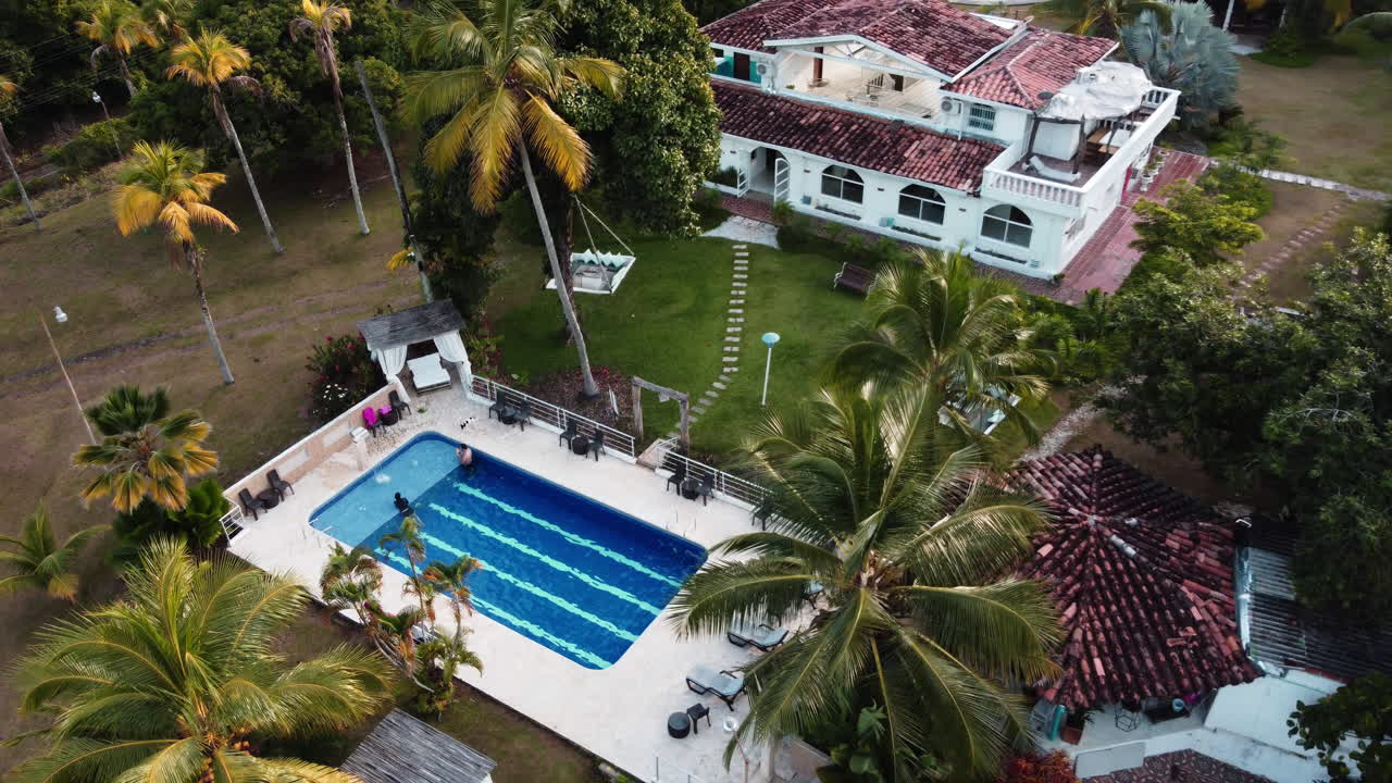 360 Aerial viewpoint of a hoilday house with a pool and palm trees in Colombia.