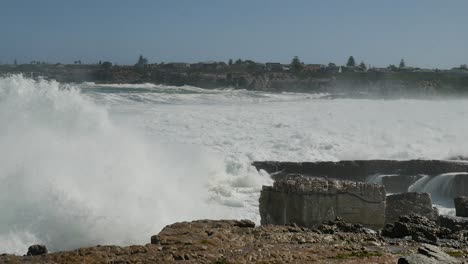 rough ocean waves crashing onto rocky coastline, slow motion