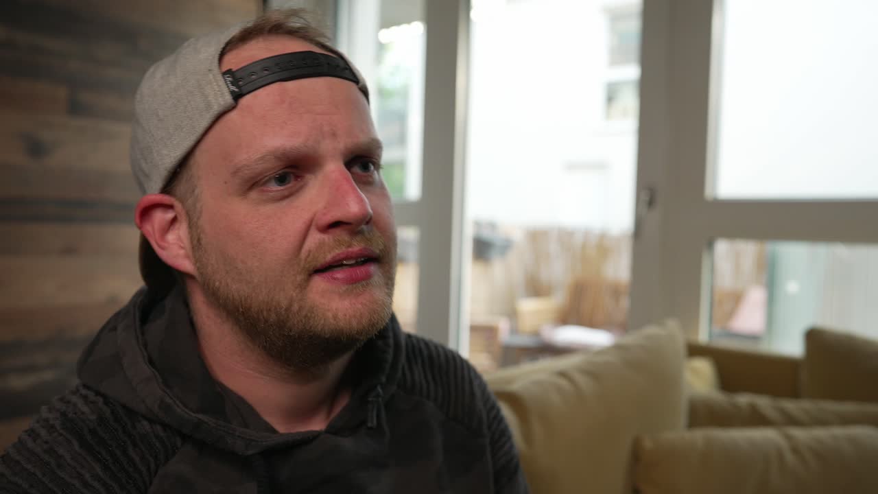 мужчина выглядит озабоченным, нервным, хмурится, разговаривает с кем-то за кадром, замедленная съемка