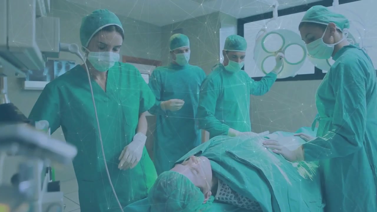 Un'equipe chirurgica regola la luce e controlla la flebo mentre i segni vitali animati aggiornano il monitor per l'intervento.
