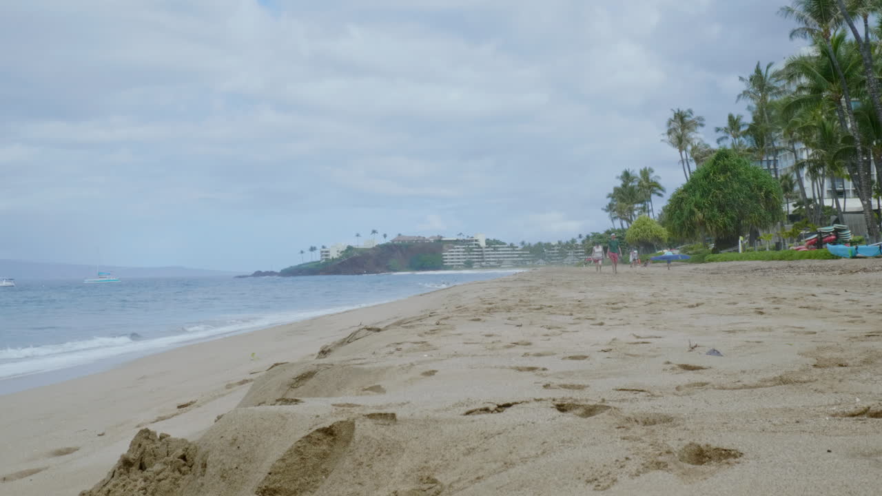 крупным планом вид волн, разбивающихся о песчаный пляж вечером под пасмурным небом