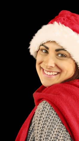 niña con sombrero de santa y ropa cálida soplando sobre las manos