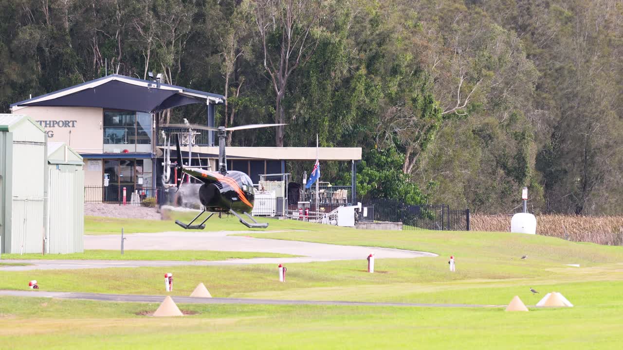 헬리터가 내려와 잔디로 된 공항에 착륙합니다.