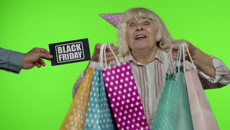 la inscripción publicitaria black friday aparece junto a la abuela alegre con bolsas de compras