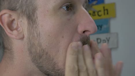 caucasian man oiling his beard with beard oil after shaving and trimming his beard and mustache