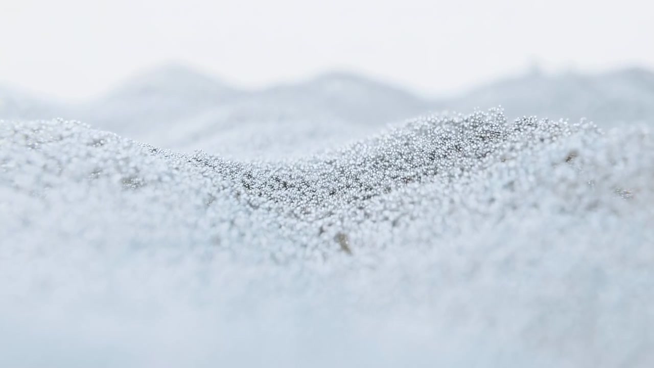 Una vista macro ravvicinata mostra innumerevoli goccioline luminose aggrappate a una rete intrecciata, mentre leggere ondulazioni si muovono attraverso l'inquadratura, con luce diffusa fredda, messa a fuoco morbida e texture traslucida stratificata.