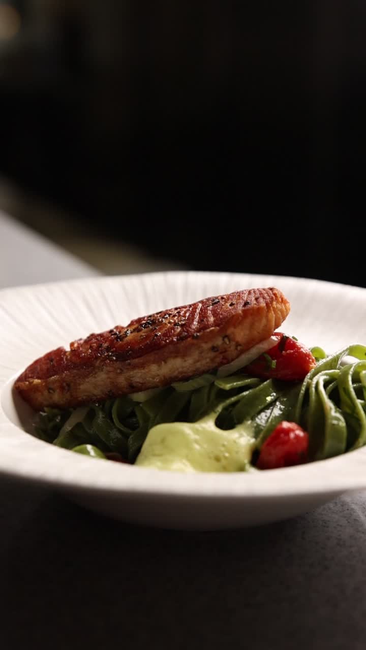 Servire salmone gourmet e pasta verde con salsa spumosa
