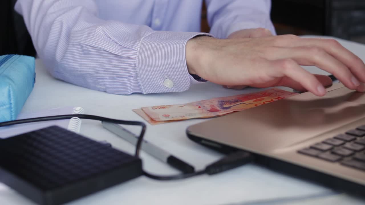Pengusaha Meletakkan Peso Argentina Dekat Laptop Saat Bekerja di Meja Kantor