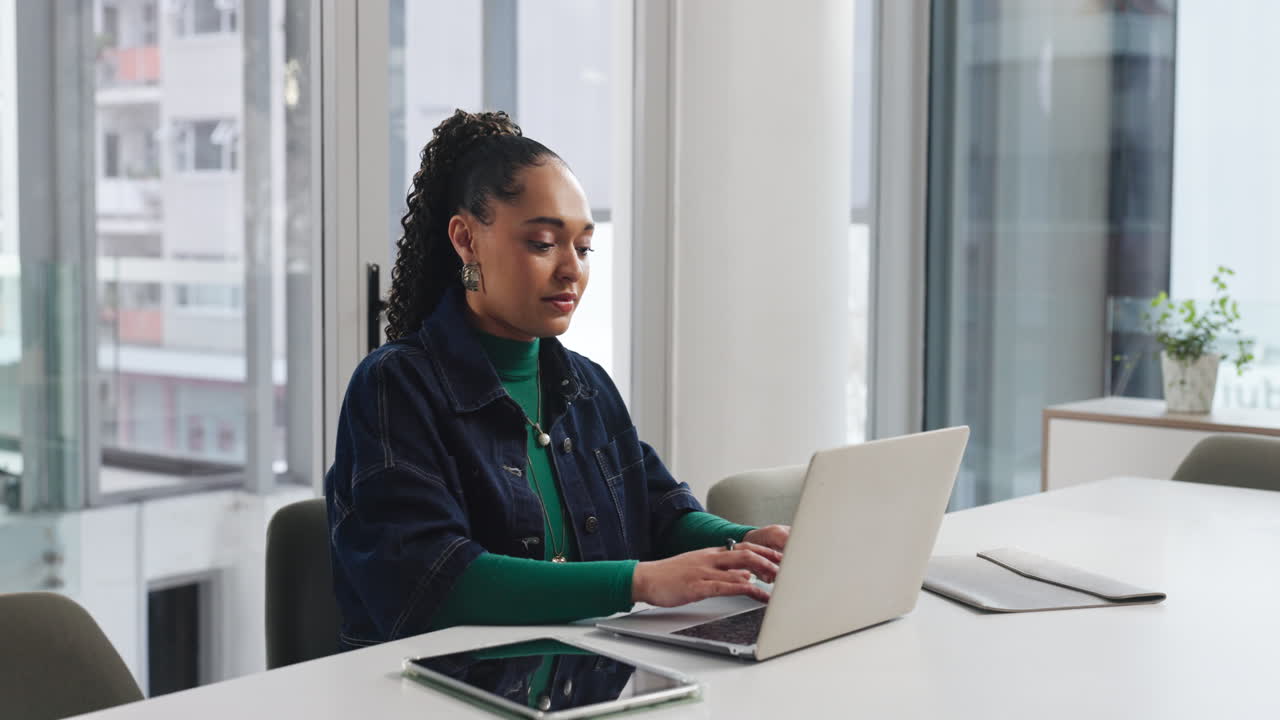 Professional woman working on laptop in modern office