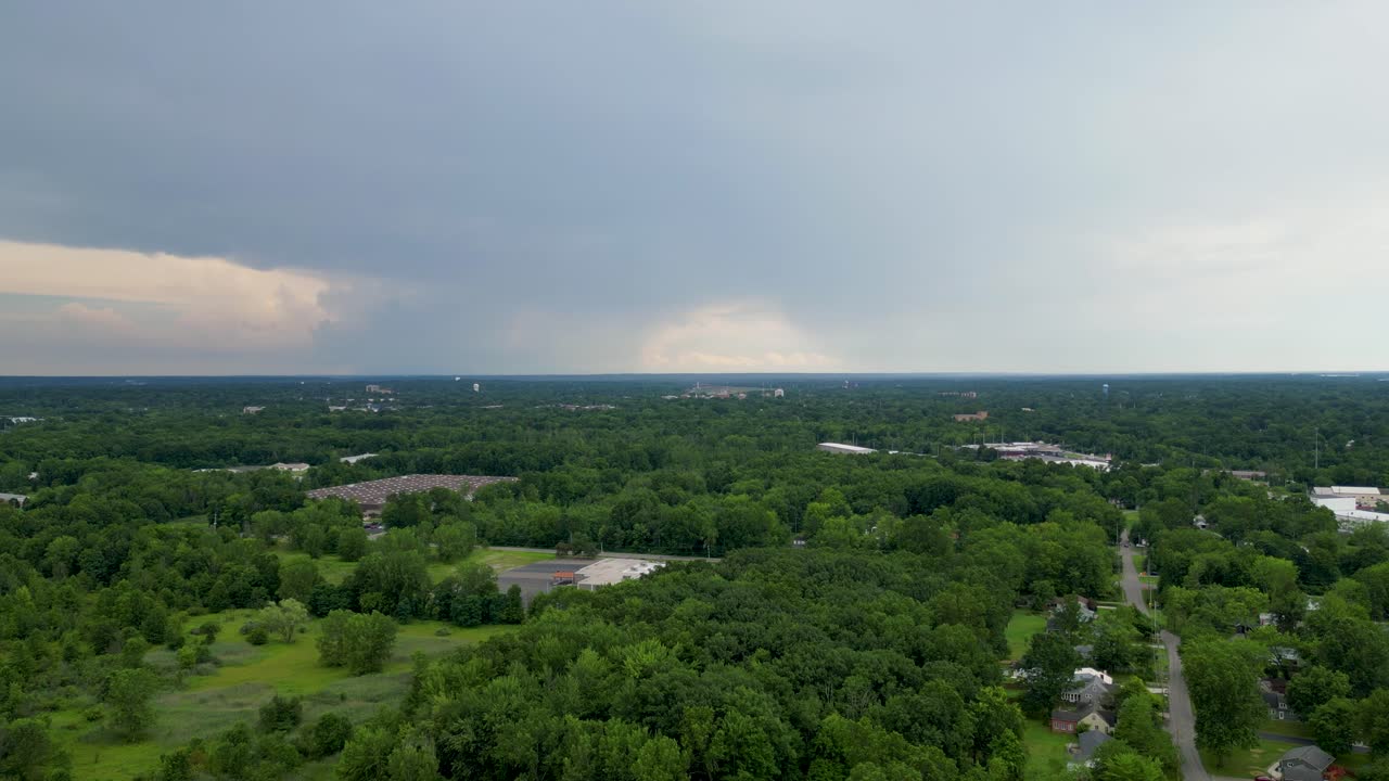 기운이 나고 구름이 많은 하늘 아래 푸른 풍경의 공중 풍경, 자연의 극적인 대조를 포착합니다.