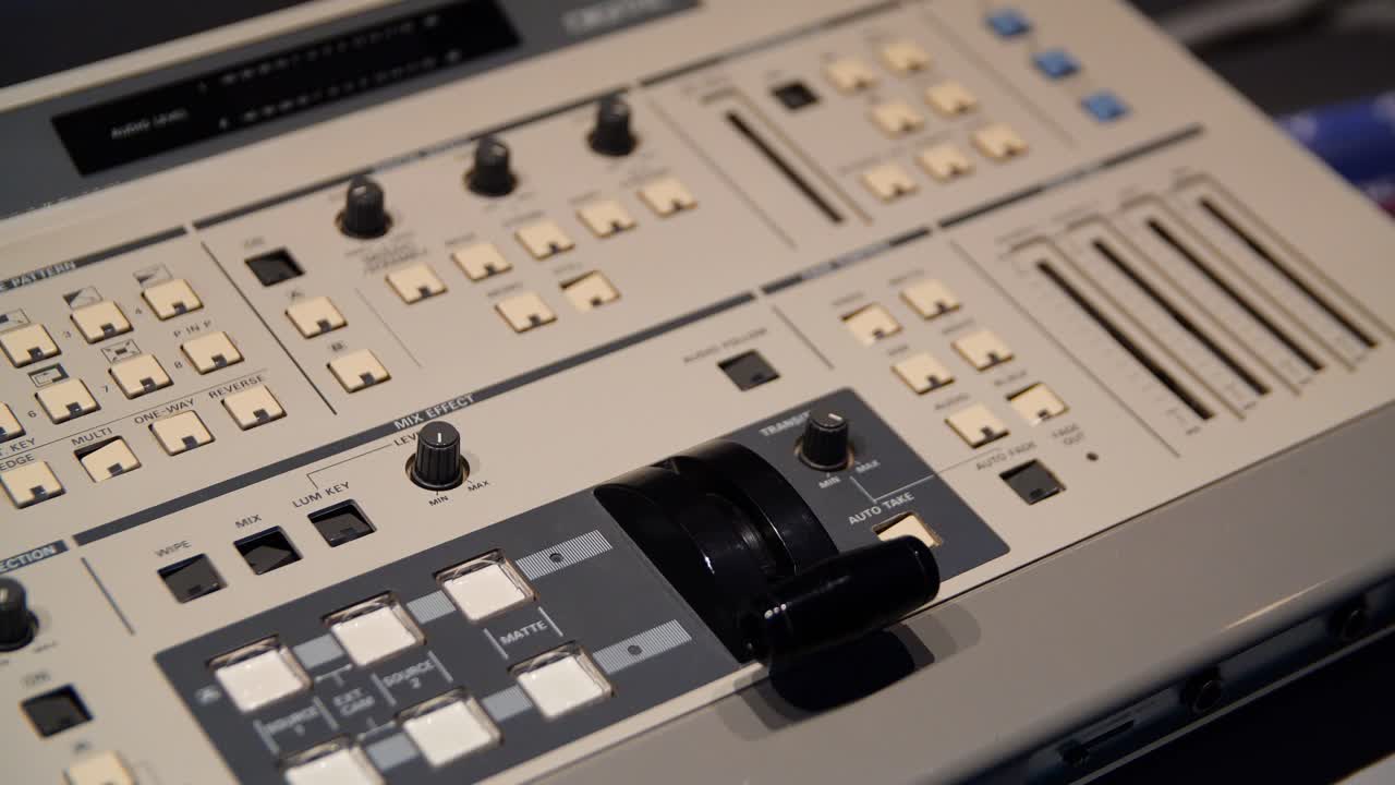 mano operando una consola de mezcla de video