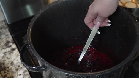 bringing the berries to a boil to make jam - stirring with a spoon