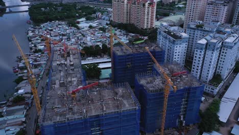drone órbita de gran proyecto de construcción residencial moderna en el sudeste asiático que se construye a lo largo de un canal con casas originales de baja altura y expansión urbana