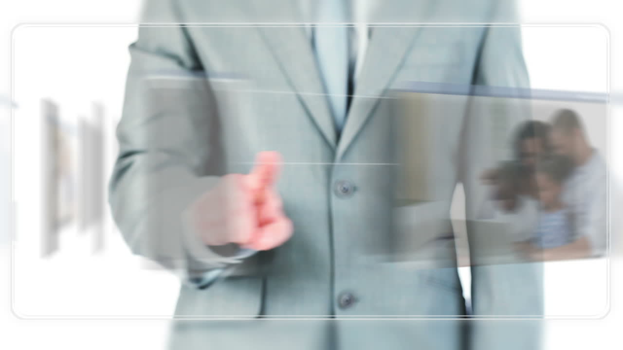 Businessman dragging videos about families using a laptop