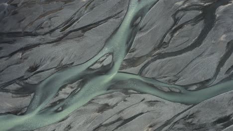 glacial river melt water with mineral sediment flows through delta in iceland