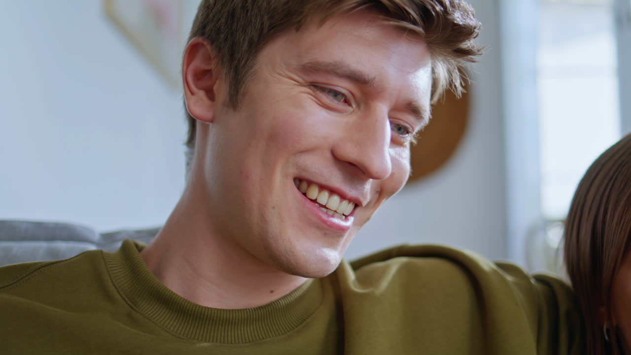 Closeup guy speaking girlfriend embracing at home sofa. Cute pair teenagers