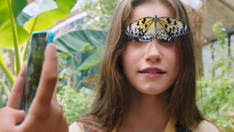 mariposa, foto de teléfono y sonrisa de niña con insecto