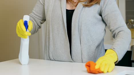 woman cleaning kitchen worktop