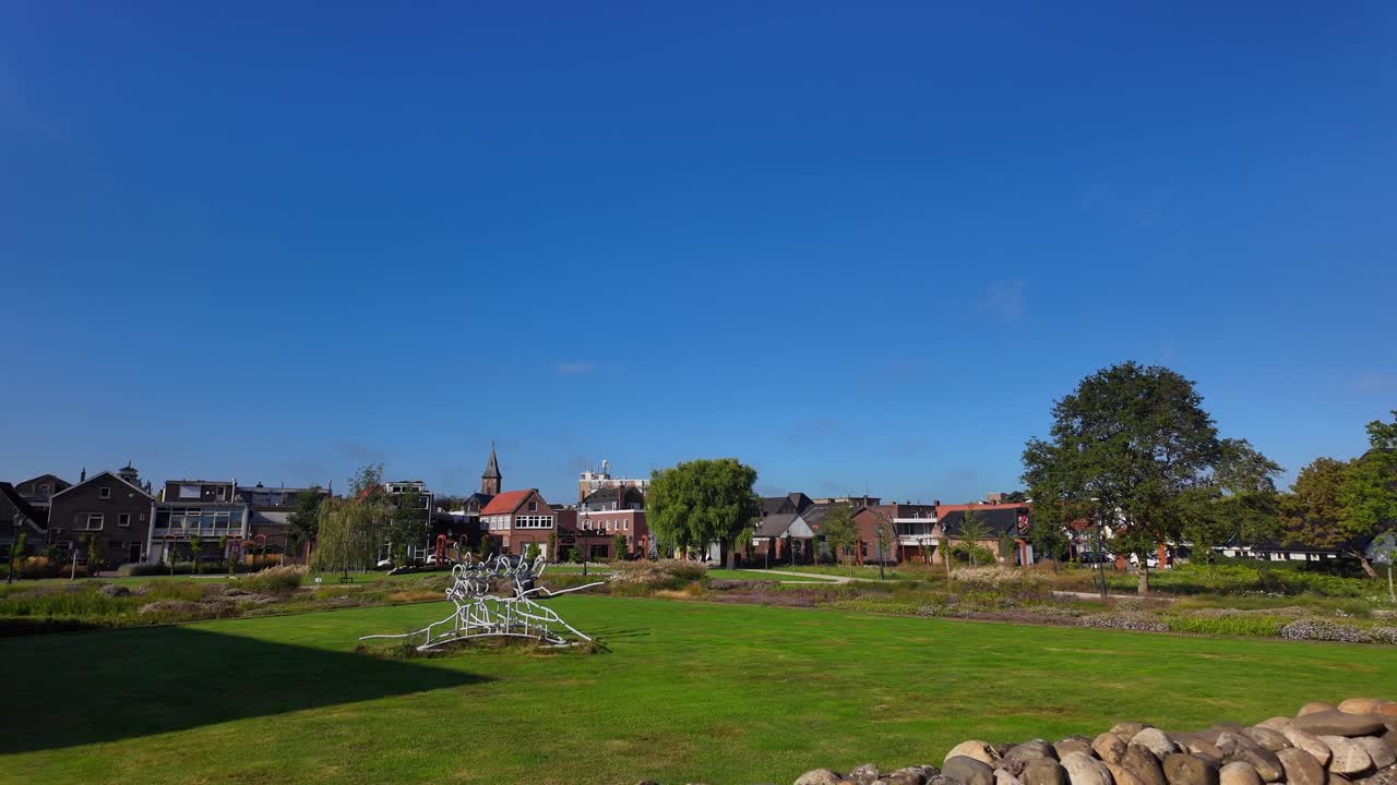 Wide view of Coevorden skyline with stone wall, church tower, trees and traditional houses beneath a bright blue sky. Location: Coevorden, Drenthe, Netherlands (Coevorden, Drenthe, Nederland)