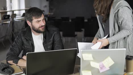 businesswoman throwing papers toward her colleague showing her anger at the office. slow motion