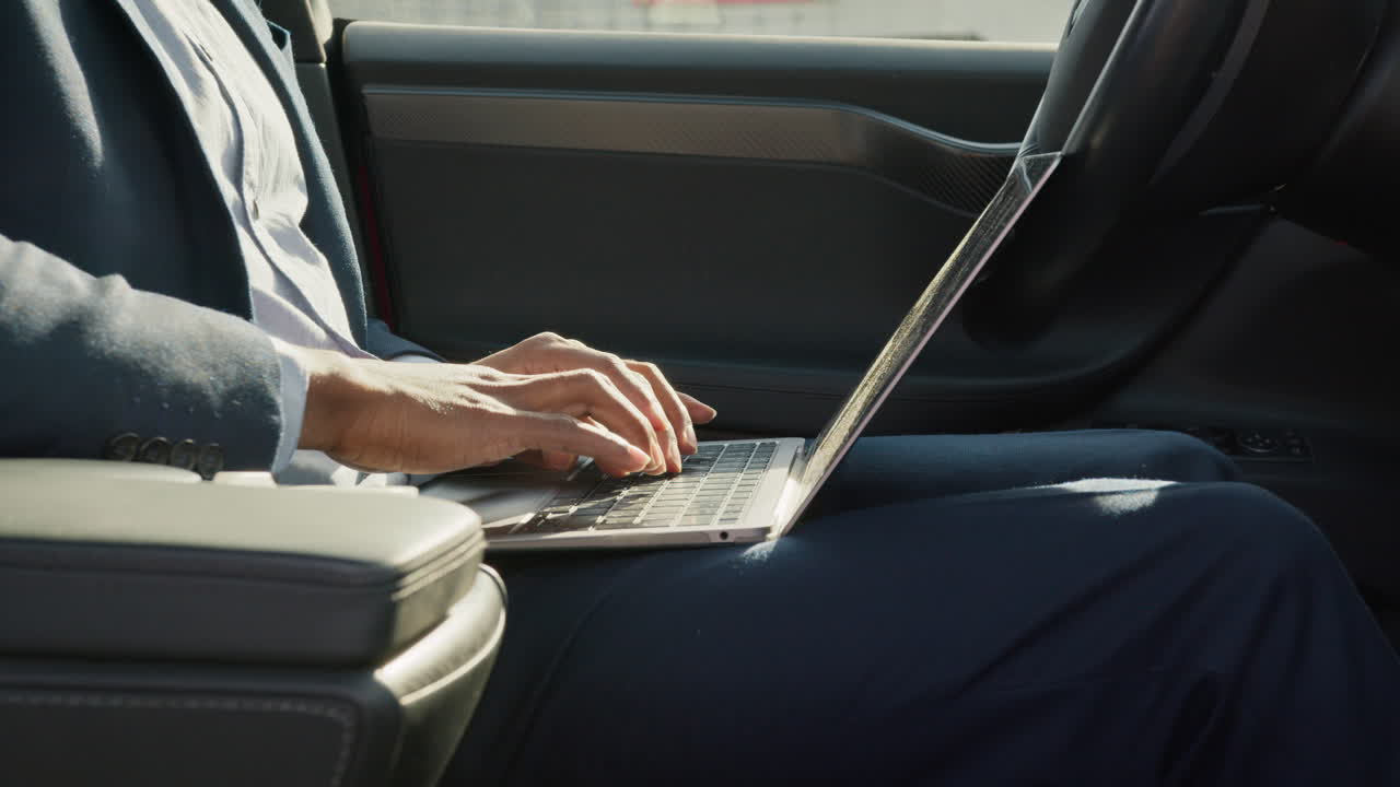 hombre de negocios trabajando en una computadora portátil en un coche