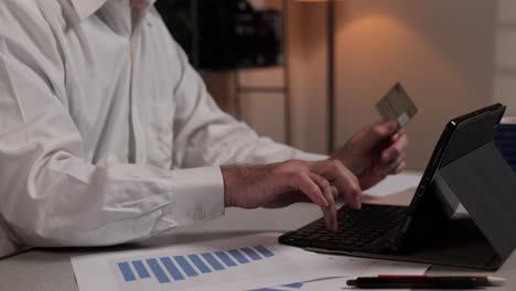 A-businessman-enters-credit-card-data-into-a-tablet-computer