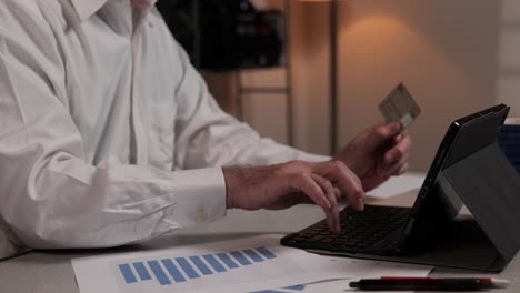 a businessman enters credit card data into a tablet computer