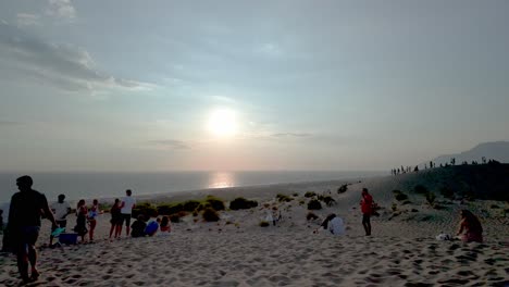 visitors enjoy the golden hour at patara, capturing memories against the stunning landscape of the dunes