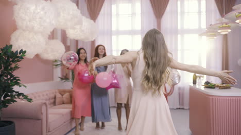 Rear-View-Of-Woman-Running-And-Hugging-Her-Friends-In-Her-Bachelorette-Party