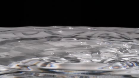 water droplets fall into rippling clear liquid, slowmo extreme closeup