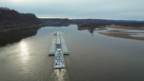 Approaching-Lansing-Iowa,-a-towboat-pushing-barges-north-on-the-Mississippi-River