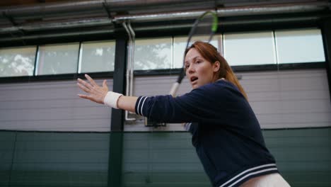 woman playing indoor tennis