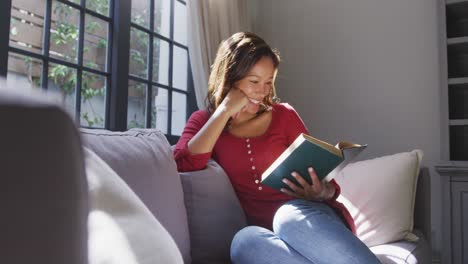 mujer de raza mixta leyendo un libro. distanciamiento social y aislamiento en cuarentena