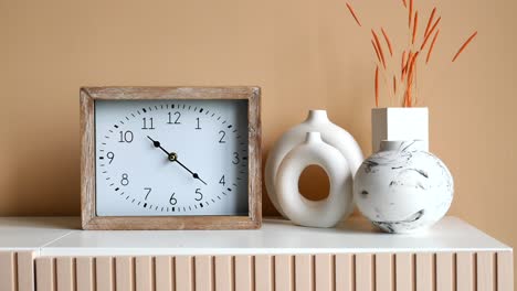 stylish home decor arrangement with clock and vases