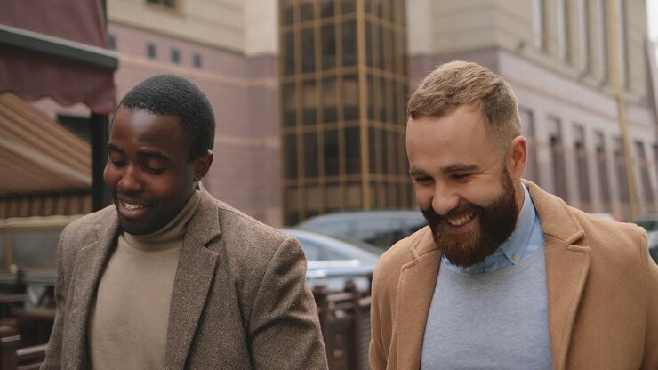 Caucasian and african american businessman in elegant clothes talking and walking down the street