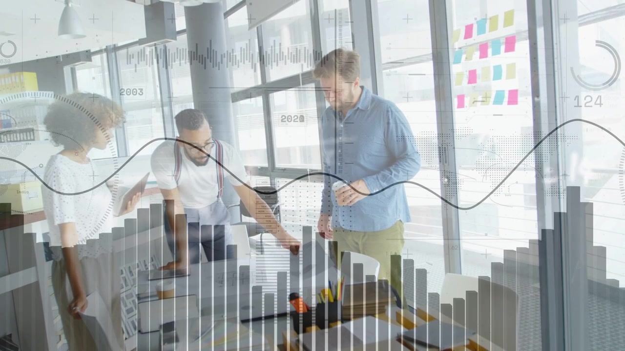 Team di design riunito attorno a un tavolo, la persona al centro indica, generando grafici in tempo reale che perfezionano i progetti.
