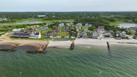 aerial pullback of green lavish landscape in cape cod reveals dennis beach and atlantic ocean